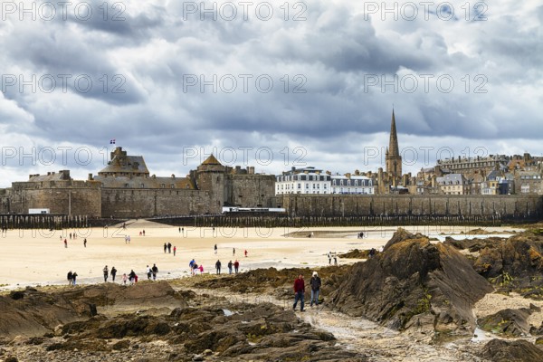 View of the city wall and cathedral from the Fort National, walkers on the beach, Saint-Malo,