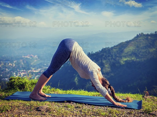 Yoga outdoors, young sporty fit woman doing Ashtanga Vinyasa Yoga asana Adho mukha svanasana,