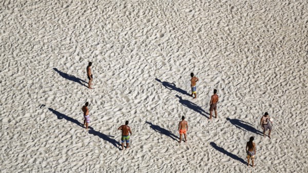 Beach volleyball on the beach of Nazaré, players cast long shadows, view from above, Portugal,