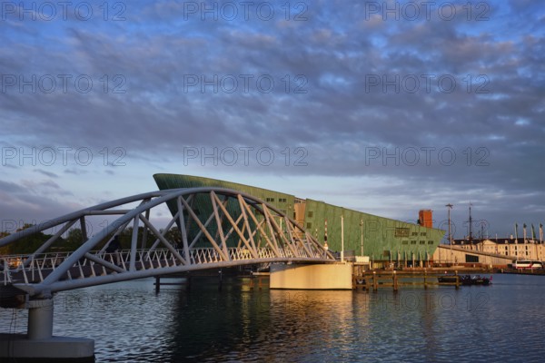 AMSTERDAM, NETHERLANDS, MAY 9, 2017: NEMO Science museum and Mr. J. van der Veldebrug bridge. It is