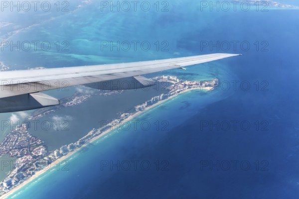Aerial view through plane window of Caribbean coastline buildings in the hotel zone, Cancun,