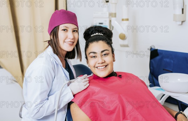 Female dentist with smiling female patient looking at camera, Professional dentist with female