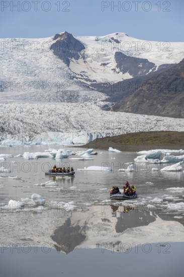 Boats with tourists in the glacier lagoon, ice lagoon Fjallsárlón, ice floes in front of glacier