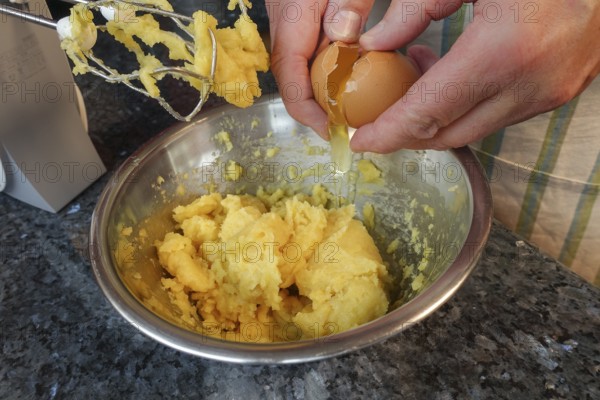 Swabian cuisine, preparing choux pastry for mini cream puffs, adding egg to raw choux pastry,