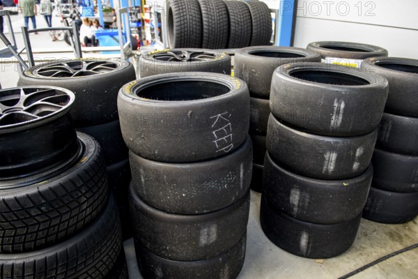 Used tyre pile of used worn tyres Racing tyres middle right Slicks left Rain tyres in front of pit