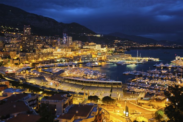Aerial view of Monaco Monte Carlo harbour and illuminated city skyline in the evening blue hour