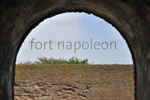 The pentagonal Fort Napoleon in the dunes near Ostend, Belgium. Viev over brick wall through window