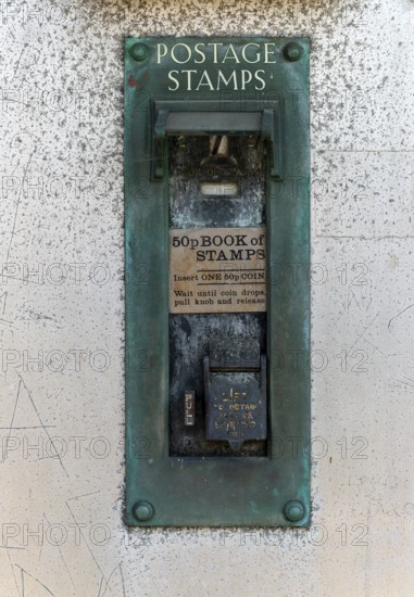 Old postage stamp coin machine no longer in use, UK