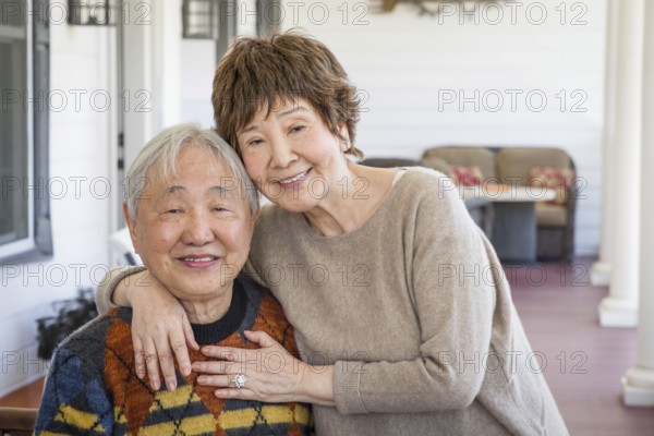 Happy senior chinese couple pose for their portrait on the porch