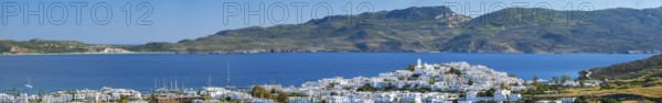 Panorama of Plaka village with traditional Greek church white painted Greek houses and ocean coast.
