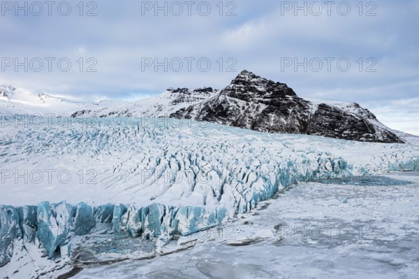 Snow-covered icebergs in the Fjallsarlon glacier lagoon, with the Öraefajökull glacier behind,