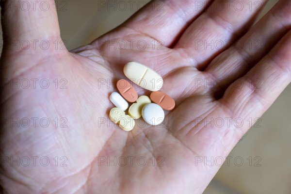 Hand holding various tablets, medicines, drugs