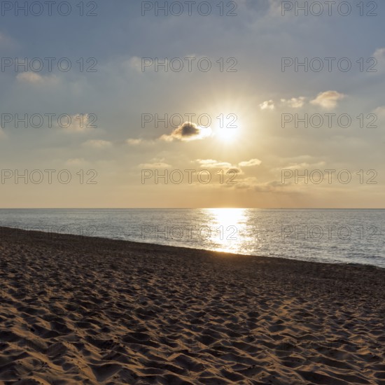 Sunbeams in a slightly cloudy sky, sunset by the sea, deserted sandy beach in autumn, Spiaggia di