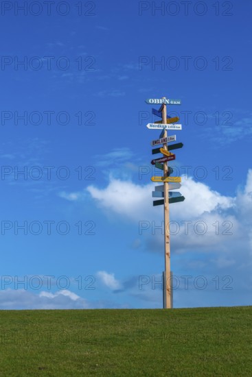 Signpost on dyke to local and world places, Nordstrand peninsula, North Frisia, Schleswig-Holstein,
