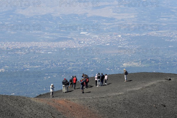 Hikers in the crater landscape of the volcano Etna, summit region, province of Catania, Sicily,