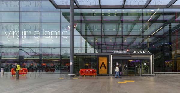 Passengers with luggage outside Virgin Atlantic, Terminal 3 building, London Heathrow Airport,