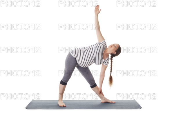 Pregnancy yoga exercise, pregnant woman doing asana Utthita trikonasana, extended triangle pose