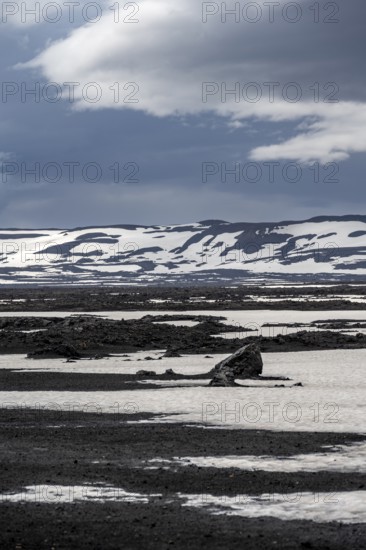 Snow-covered volcanic landscape with volcanic sand and petrified lava, crater of Askja volcano,
