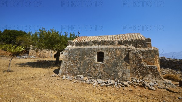 Agios Georgios, chapel, ruins of buildings, stone houses, dry meadow, cloudless blue sky, northeast
