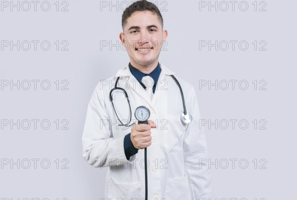 Cheerful doctor holding blood pressure monitor. Young doctor showing blood pressure monitor