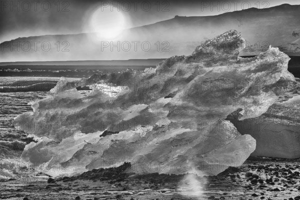 Backlit block of ice, b&w image, beach at glacier lagoon Jökulsarlon, Breiðamerkursandur, south