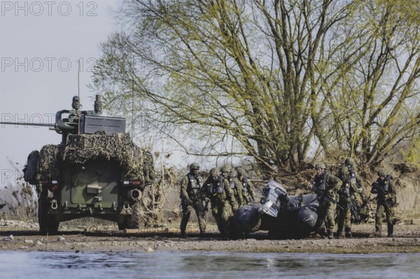 Czech and German soldiers launch an inflatable boat into the Elbe as part of the military exercise