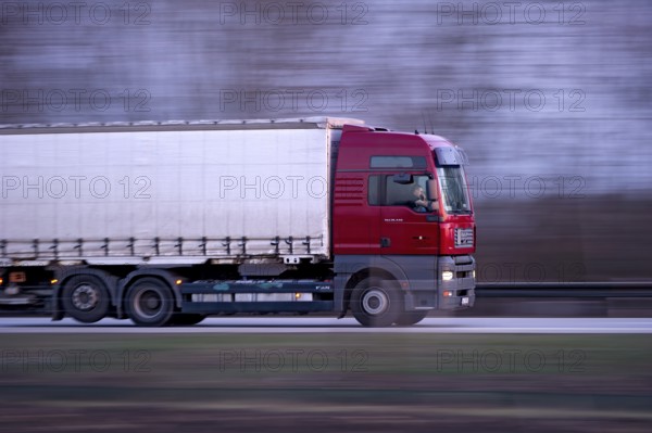 Unconcentrated driver in truck, lorry, semi-trailer MAN TGA 26.440 driving fast on the A92