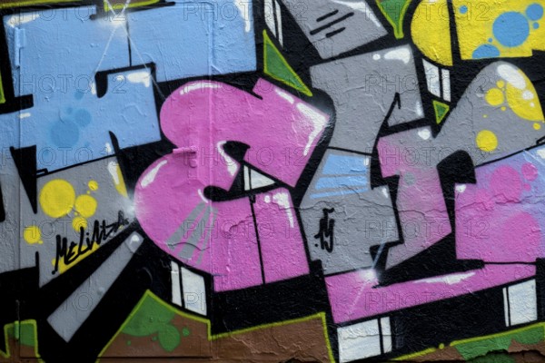 Abstract graffiti art in vibrant colours with dynamic shapes on a rough wall, Landau,