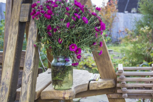 A bouquet of asters in a glass jar