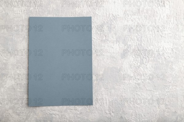 Blue paper business card, mockup on gray concrete background. Blank, flat lay, top view, still