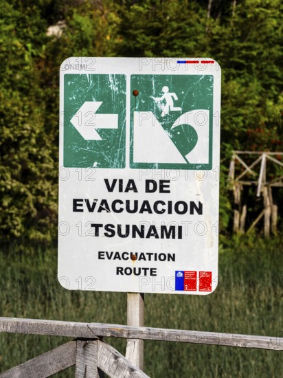 Signpost showing evacuation route in case of a tsunami, Caleta Tortel, Aysen region, Patagonia,