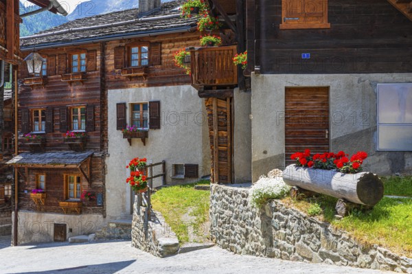 Old houses with flower boxes in front of windows and balconies, historic village centre, Grimentz,