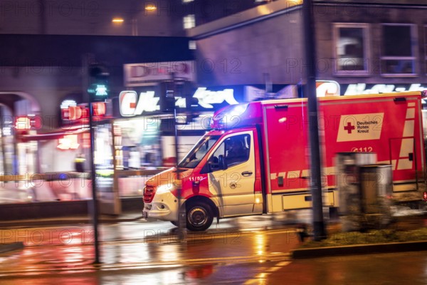 Ambulance on alarm, DRK, Essen fire brigade, rainy weather, city centre, evening, Essen, North