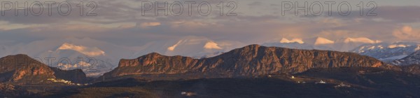 Panoramic shot, Dramatic landscape with snow-capped mountains and rock formations under a cloudy