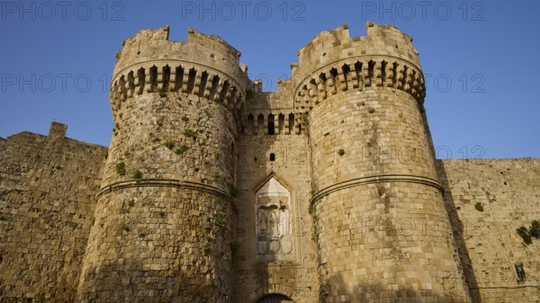 Fortress with impressive battlements and massive Tor tor under a clear blue sky, sea gate, harbour