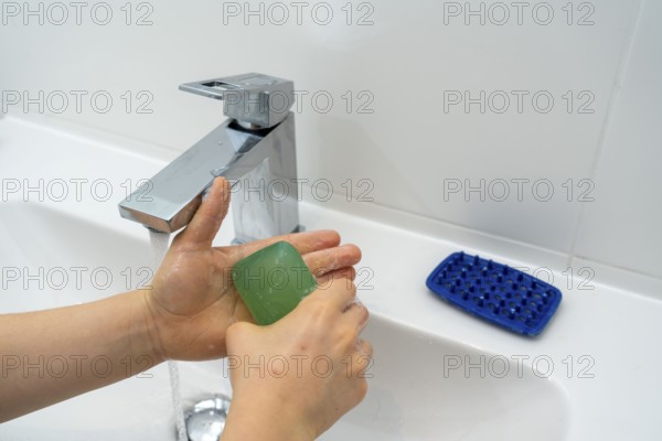 Domestic hygiene, washing hands, with a bar of soap, boy 9 years old