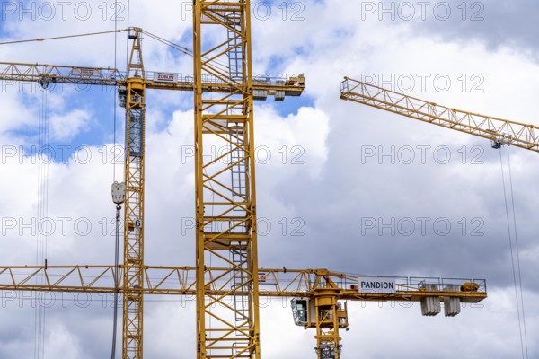 Construction cranes, on a large construction site in Düsseldorf, construction of condominium in the