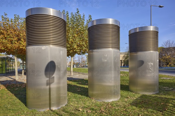 Exhaust air ducts for building air conditioning, city trees, lawn, blue cloudless sky, Dresden,