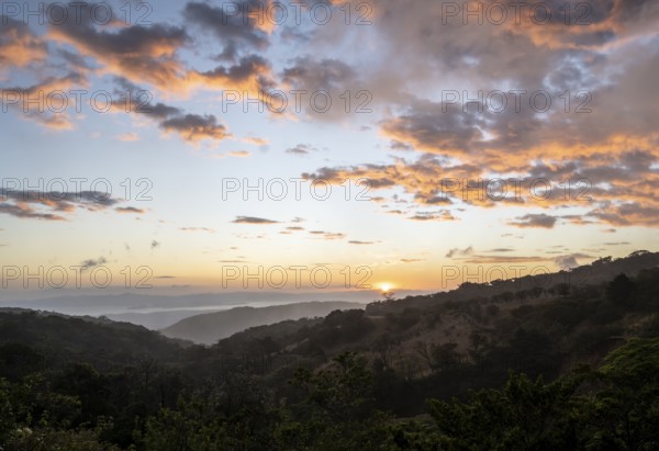 View to the sea over wooded hills, at sunset, cloud forest, Monte Verde, Puntarenas province, Costa