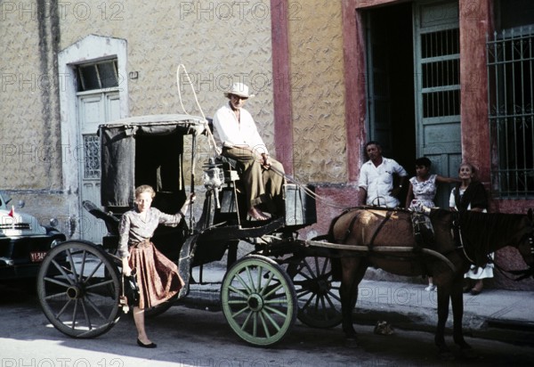 Female tourist in front of the Surrey horse-drawn carriage, Mexico, around 1961, Central America