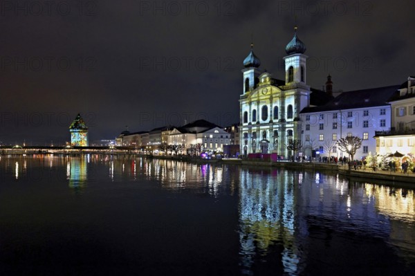 Water tower and Jesuit church on the right with light installation, on the Reuss at dusk, Old Town,