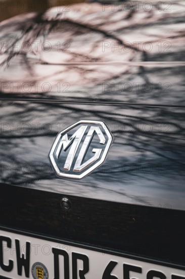 MG logo on the back of a black car with reflective roof, e-car sharing vehicle from Deer Mobility,
