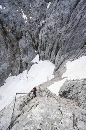 Mountaineer with helmet in a secured via ferrata, Zugspitze via ferrata, ascent to the Zugspitze,