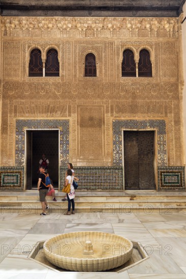 Patio del Cuarto Dorado with tourists, arabesque Moorish architecture, arched windows and