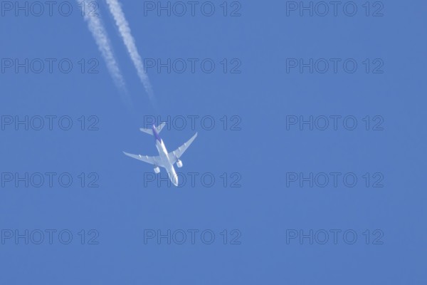 Airbus A300 jet aircraft of Fedex airlines flying in a blue sky with a vapor trail or contrail