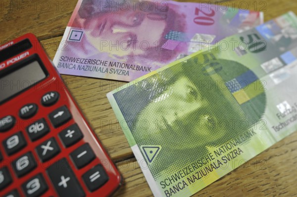 Swiss banknotes and pocket calculator