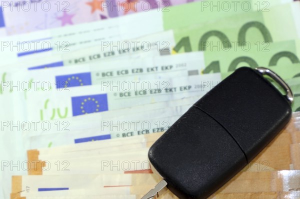 Euro banknotes and car keys as a symbol for car costs