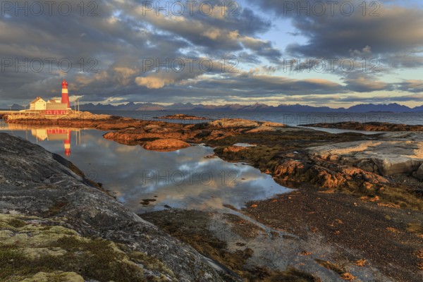 Lighthouse reflected in water, morning light, clouds, mountains, coast, Tranoy, Ofoten, Norway,