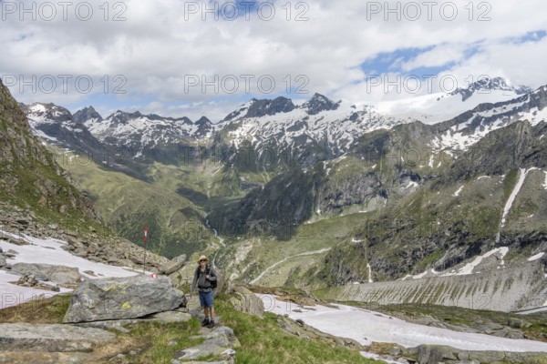 Mountaineers on a hiking trail in front of a picturesque mountain landscape, rocky mountain peaks