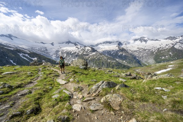 Mountaineer on hiking trail in picturesque mountain landscape, mountain peak with snow and glacier
